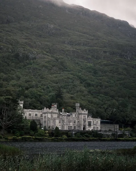Вертикальный Снимок Монастыря Аббатства Кайлемор Ирландии Против Большой Горы Мрачный — стоковое фото