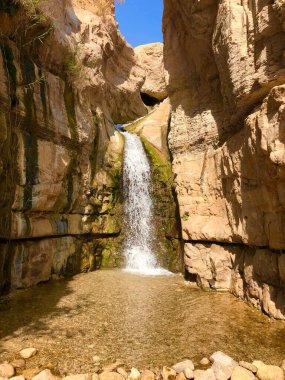 Güneşli bir günde Ein Gedi Reserve uçurumlarındaki şelalenin dikey görüntüsü