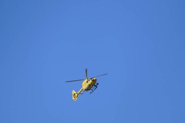 Mavi gökyüzünde uçan bir helikopter