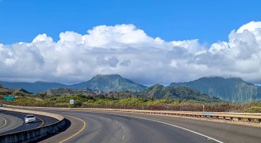 Oahu, Hawaii 'de dağlarla çevrili bir otoyol manzarası.