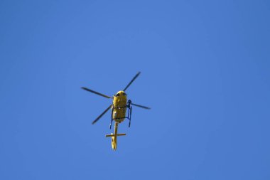 Mavi gökyüzünde uçan bir helikopter