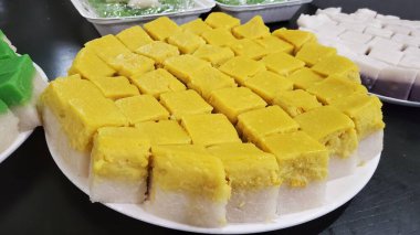 Malezya tatlısının yatay görüntüsü, beyaz bir tabakta parlayan elmalı ev yapımı seri mukalar.