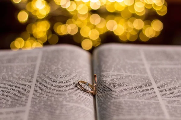 Een Close Van Twee Trouwringen Een Bijbel Met Bokeh Gouden — Stockfoto