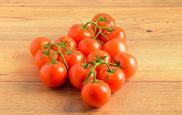 Närbild Saftiga Röda Tomater Vinrankor Ett Träbord — Stockfoto