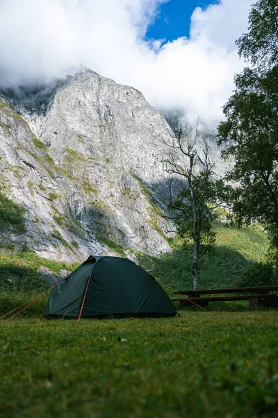 雲の中の山に対するキャンプテントの垂直ショット — ストック写真