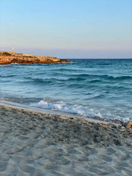 砂の海岸で海の水しぶきの垂直ショット — ストック写真