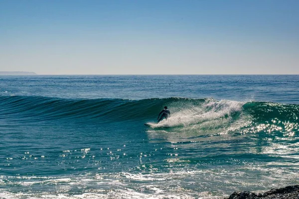 포르투갈 리스본의 아름다운 청록색 바다에서 파도를 파도타기하는 사람을 매혹적으로 — 스톡 사진