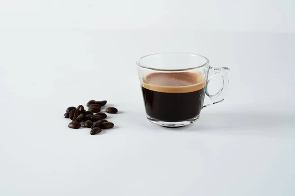 Ένα Ποτήρι Espresso Κοντά Στους Κόκκους Καφέ Μια Λευκή Επιφάνεια — Φωτογραφία Αρχείου