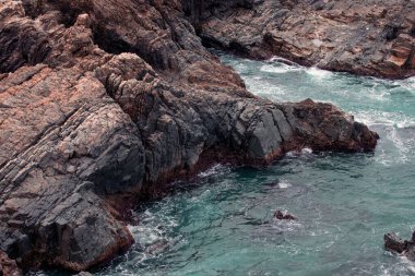 Güneşin doğuşu sırasında sahildeki büyük kayaların güzel manzarası