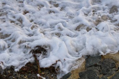 Urville-Nacqueville 'deki kayalık sahile vuran köpüklü deniz dalgalarının yüksek açılı görüntüsü.