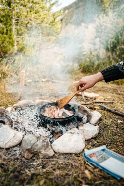 Kamp ateşinde arka planda ağaçlarla çırpılmış yumurta görüntüsü.
