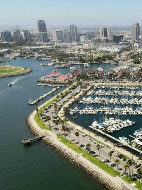 Güneşli bir günde göl kenarındaki modern binaların dikey görüntüsü.