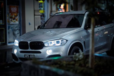 Geceleri şehirde dolaşan bir BMW X3 SUV.