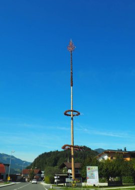 Güneşli bir günde mavi gökyüzü arkaplanı olan bir direğin dikey görüntüsü.