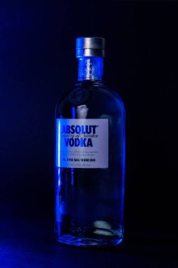 Üzerinde mavi ışıklar parlayan sınırlı sayıda üretilmiş bir Absolut votka şişesinin dikey çekimi.
