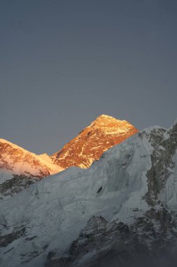 Nepal 'de gün batımında gökyüzü arka planında karlı Everest Dağı' nın dikey manzarası