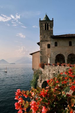 Tepedeki antik bir binanın dikey yakın çekimi. Arka planda okyanus var.
