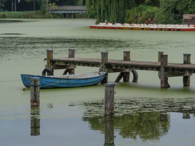 Almanya, Borken 'de bir göldeki iskeleye bağlı küçük bir kayık.