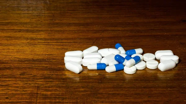 Uma Pilha Comprimidos Azuis Brancos Mesa Madeira — Fotografia de Stock