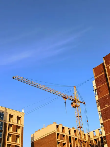 Кран Окруженный Высокими Коричневыми Зданиями Городе Ярко Голубым Небом — стоковое фото
