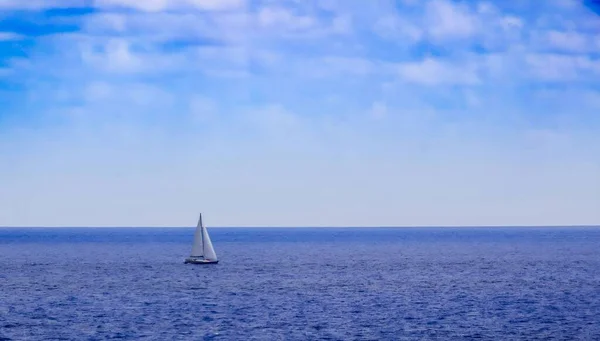 Mavi Denizin Ufuklarında Yalnız Beyaz Bir Yelkenli — Stok fotoğraf