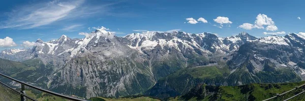 Een Panoramisch Shot Van Besneeuwde Bergtoppen Tegen Een Blauwe Lucht — Stockfoto