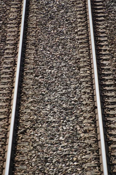 Вертикальный Крупный План Железнодорожных Путей Небольших Камней Вокруг — стоковое фото