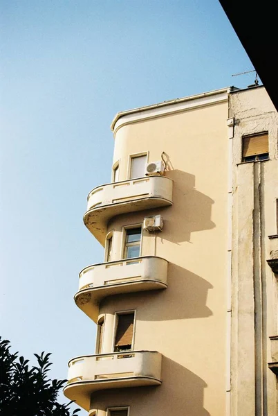 stock image A vertical shot of a residential building with balconies under a blue sky.