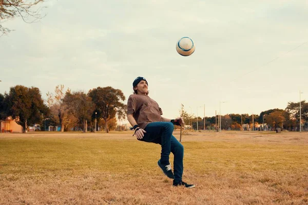 森の反対側の畑でサッカーをする男 — ストック写真