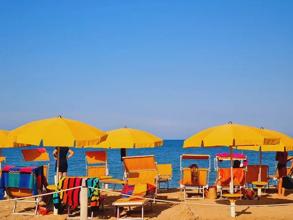 Zbliżenie Ujęcie Jasnożółtych Parasoli Plaży Ludzi Relaksujących Się Przed Błękitnym — Zdjęcie stockowe