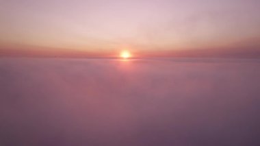 Bulutların üstündeki günbatımı manzarası.