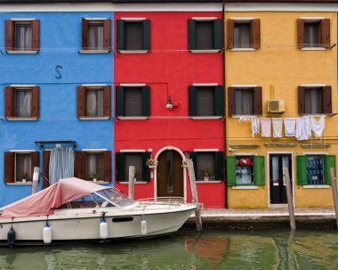 Burano İtalya 'da bir kanalın yakınındaki renkli binalar hattı.