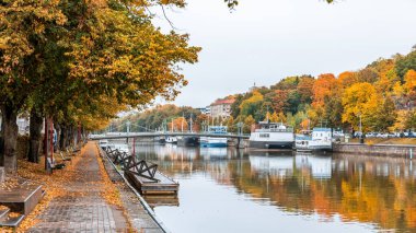 Sonbaharda Finlandiya 'nın Turku kentinde sonbahar yaprakları arasında kayıkla Aura nehrinin manzarası