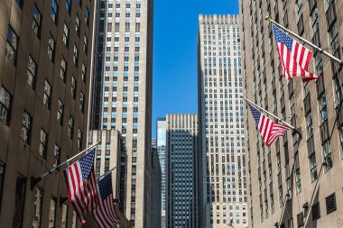 Güneşli bir New York gününde binalarda asılı Amerikan bayraklarının güzel bir fotoğrafı.