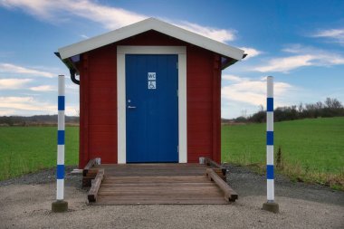 İsveç 'in kırsal kesiminde küçük, temiz bir umumi tuvaletin önünde.