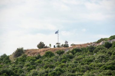 Bir tepenin üzerindeki Yunanistan bayrağının alçak açılı görüntüsü