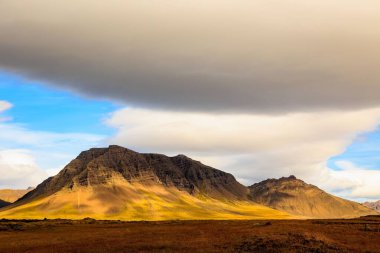 Mavi gökyüzünün altındaki dağ manzarası.