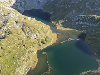 Uçurumlar arasındaki gök mavisi barajın kuş bakışı görüntüsü