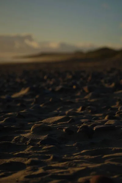 日没時に砂浜の丸い石の垂直選択的な焦点 — ストック写真