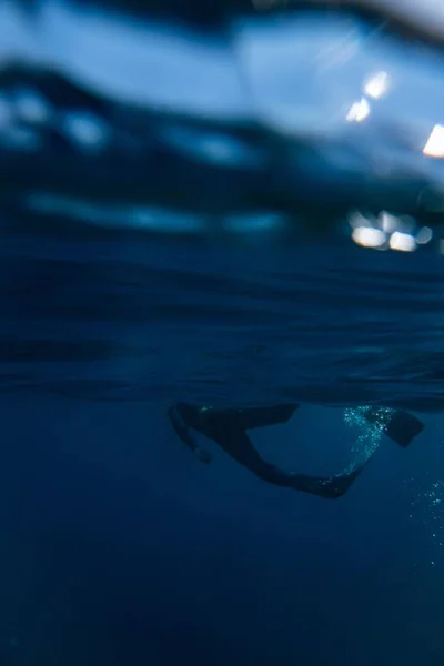 暗い夜の水に潜る者の垂直ショット — ストック写真