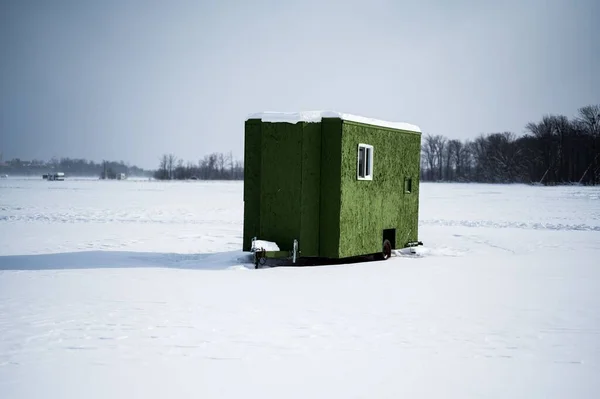 stock image A green ice fishing hut on a frozen lake with on a sunny winter day