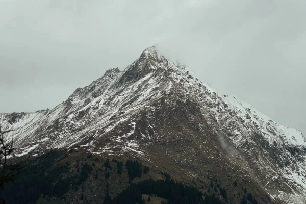 Ett Landskap Ett Berg Täckt Med Snö Gråmulen Himmel Vintern — Stockfoto