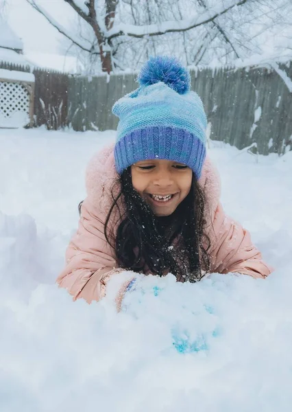 在冬季暴风雪期间 一个学龄前女孩在户外玩 在雪地里玩着冬衣 — 图库照片