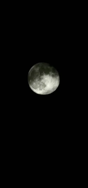 在乌黑的天空中 一颗布满阴影的满月的垂直镜头 — 图库照片