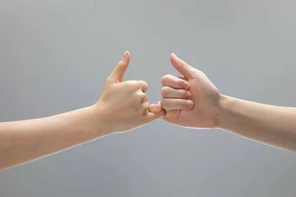 灰色の背景の前に手を触れるのを助ける2つのクローズアップショット — ストック写真
