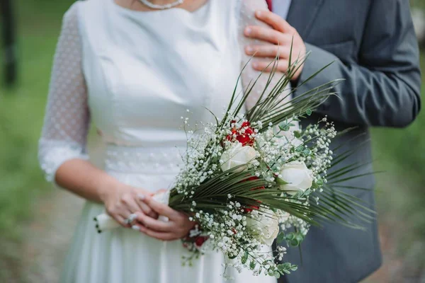 庭に花束を持った白いドレスの新郎新婦 — ストック写真