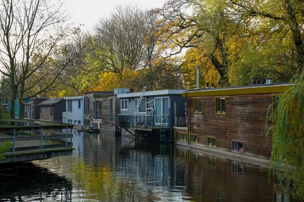 Πλωτά Σπίτια Στα Κανάλια Του Άμστερνταμ Στην Ολλανδία Πολύχρωμα Δέντρα — Φωτογραφία Αρχείου
