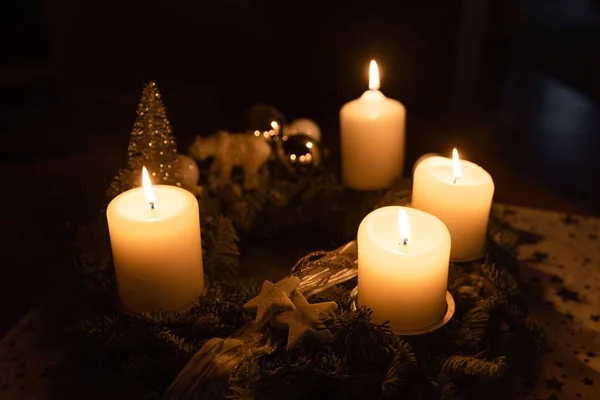 在一张木制桌子上燃着蜡烛的特写镜头 背景是一棵圣诞树 — 图库照片