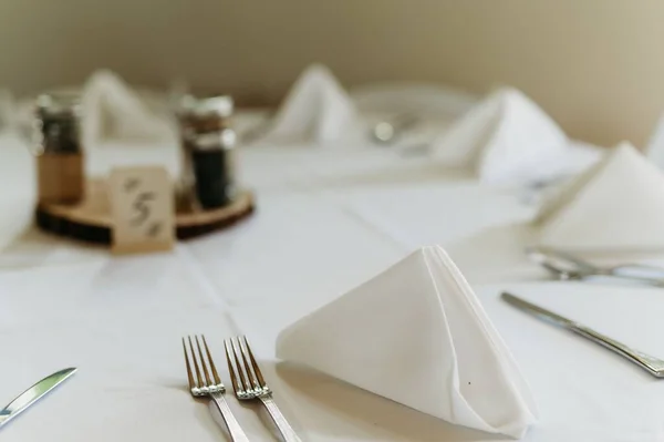 テーブルの上の銀製のフォークとナイフに白いカバーとガラス瓶が付いた木製のトレイ — ストック写真