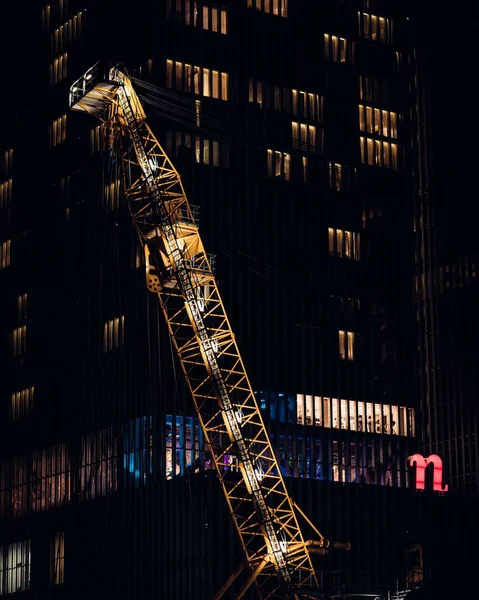 Una Grúa Torre Iluminada Por Edificio Alto Apartamentos Por Noche — Foto de Stock